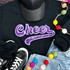 PURPLE Cheer Sequin Patch, purple sequined cheerword patch with white border on black sweatshirt.