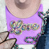 RAINBOW LOVE Sequin Patch, colorful embroidered patch with the word 'Love' in rainbow colors on a purple t-shirt surrounded by accessories.