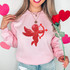 Red CupID Sequin Patch, shiny red applique of Cupid with bow and arrow on pink sweatshirt.