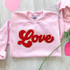 RED LOVE Chenille Patch, pink sweatshirt with red embroidered 'Love' patch.