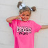 Loved Mini DTF Heat Transfer, a colorful and fun heat transfer design on a pink kids' T-shirt worn by a smiling girl with pigtails and white bows.