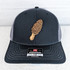 Morel Leather Hat Patch, a detailed patch of a morel mushroom attached to a black and gray trucker cap.