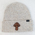 Big Mushroom Leather Hat Patch, beige knitted beanie with specks of color and a mushroom-shaped leather patch on the front.