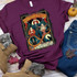 Vintage Sanderson Sisters Screen Print Heat Transfer on a maroon t-shirt, featuring three witches with a Halloween-themed design and text.