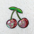 Cherry Embroidered Sequin Hat/Patch, embroidered patch featuring cherries with green leaves and pink, red, and iridescent sequins for decorative embellishment.