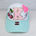 Cherry Embroidered Sequin Hat/Patch, a light blue trucker cap with embroidered patches including cherries, a pink heart, a pink letter K with gold glitter outlines, and a silver lightning bolt.