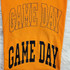 Rhinestone & Glitter Black Game Day Transfer SET, close-up of orange fabric with black glittered text and rhinestone accents celebrating game day.