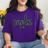 Eagles Sequin Patch, a shiny black and silver embroidered patch in the shape of the word 'eagles' worn on a purple T-shirt.
