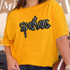 Spartans Sequin Patch, a sparkling black and silver embroidered patch spelling 'spartans' on a yellow t-shirt.