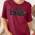 Touchdown Sequin Patch, embroidered 'touchdown' text with black outline and sequin details on a maroon T-shirt.