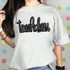 Touchdown Sequin Patch, metallic black sequin patch spelling 'touchdown' on a gray T-shirt.