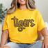 Tigers Gold Sequin Patch, close-up of a woman wearing a yellow T-shirt with a glittery tiger logo patch.