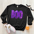 Purple BOO Sequin Patch, sequined purple and pink patch with the word 'BOO' on a black sweatshirt.