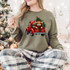Red Truck Cow DTF Heat Transfer, Christmas sweater with a festive graphic of a cow with horns in the back of a red truck and a decorated Christmas tree