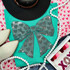 Pink Bow with Hearts Spangle Heat Transfer, close-up of a teal fabric with a rhinestone-embellished pink bow with heart pattern design.