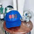 Patriotic Pops DTF Heat Transfer, a blue trucker cap with patriotic-themed popsicle designs on the front panel.