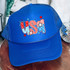 USA Patterned Retro DTF Heat Transfer, blue trucker hat with patriotic red, white, and blue star and stripe designs in the letters 'USA' on the front panel.