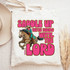 Saddle Up We're Riding With The Lord DTF Heat Transfer, colorful design on a white tote bag featuring a woman riding a horse wearing a cowboy hat and western clothing.