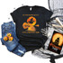 Dark Desert Highway Witch Screen Print Heat Transfer, Halloween themed black T-shirt with witch flying on a broomstick against a full moon with trees and water reflection