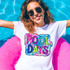 Pool Days Scribble Doodle DTF Heat Transfer, colorful pool-themed design on a white T-shirt worn by a woman enjoying swimming pool lifestyle.