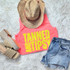 Neon Yellow Tanned & Tipsy Fluffy Patch, stylish summer outfit with a pink tank top, denim shorts, straw hat, and wedge sandals.