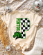 Checkered Mascot N-Z DTF Heat Transfer T-shirt with a green horse mascot and P inside a checkered letter P, on a beige leopard print fabric with disco balls, dried grass, and a white boot around.