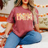 Fall Patterned Names DTF Heat Transfer, colorful name design with autumn-themed patterns on a woman's maroon t-shirt.