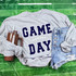 Game Day with Silicon Laces Patch - 10 Colors, casual outfit including a gray sweatshirt with 'GAME DAY' patch, denim shorts, and a brown tumbler, laid out on a green football field background.