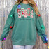 Patterned Jesus Is The Reason For The Season DTF Heat Transfer, Christmas-themed sweatshirt with colorful patterned letters spelling JESUS and festive decorations.