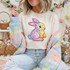 Faux Sequins Pastel Bunny DTF Heat Transfer, colorful pastel bunny design embroidered on a white T-shirt, surrounded by pastel Easter decorations.