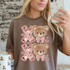 Faux Sequin & Fluffy XOXO Bear DTF Heat Transfer, design featuring teddy bears with pink bows and sequined XOXO letters on a brown T-shirt.