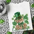 Lucky Bear DTF Heat Transfer, St. Patrick's Day themed design featuring a teddy bear wearing a green glittery top hat and bow, surrounded by shamrocks and green stripes on a white T-shirt.