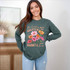 The Lord Is Greater Wild Flowers DTF Heat Transfer, a woman wearing a green sweatshirt with floral design and inspirational quote.