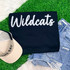 Wildcats Fluffy Chenille Patch Transfer, varsity game day patch with white chenille lettering on black fabric, paired with denim shorts and a beige cap.