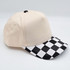 Black & White Cotton Checkered Blank Hats, stylish baseball cap featuring a black and white checkered brim and plain beige crown made of cotton fabric.