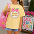 Polka Dot Grade Apple DTF Heat Transfer, colorful polka dot design with a pink bow on an apple shape, with the words 'kinder garten' in gold glitter text on a yellow T-shirt worn by a young girl.