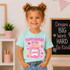 Is My Jam Back to School DTF Heat Transfer | Grades Pre-K–4, a young girl wearing a light blue t-shirt with colorful back to school design and the phrase 'Fourth Grade is My Jam' printed on it.