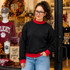 Blank Mockneck Sweatshirt — Preorder | Multiple Colors, woman wearing black mock neck sweatshirt with red cuffs and collar, paired with light blue jeans, standing outside a clothing store.