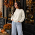 Blank Mockneck Sweatshirt — Preorder | Multiple Colors, woman wearing a cream-colored mockneck sweatshirt and light blue jeans, standing outside a boutique decorated for fall with pumpkins and autumn leaves.