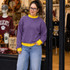Blank Mockneck Sweatshirt, woman wearing purple sweatshirt with yellow cuffs and collar in a clothing store.