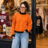 Blank Mockneck Sweatshirt — Preorder | Multiple Colors, woman wearing an orange sweatshirt with black collar and cuffs, casual outfit, inside a clothing store