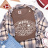 Football Doodle CHOOSE YOUR COLOR DTF Heat Transfer, image of a brown T-shirt with a white football-themed doodle design surrounded by sports-related icons and text.