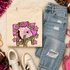 Pink Glitter Mascot - 62 teams - DTF Heat Transfer, featuring a vibrant pink glitter mascot design for team spirit on a beige sweatshirt, surrounded by casual apparel and accessories.