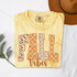 Patterned Fall Vibes DTF Heat Transfer, yellow t-shirt with fall-themed patterns and the words 'Fall Vibes' printed on it.