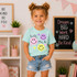 Hello Grade Smiley DTF Heat Transfer, colorful smiley face design on a girl's T-shirt with handwritten style text.
