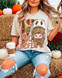 Boo Heifer Highland Cow DTF Heat Transfer, a colorful and playful graphic featuring a Highland cow dressed as a ghost with the text 'BOO HEIFER' on a fall-themed background with pumpkins and hay in autumn setting.