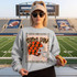 Game Day Polka Dot Helmet DTF Transfers | Football Color Combo Collection, a woman standing in a football stadium wearing a sweatshirt with football helmet design and holding a hot dog.