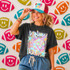 Neon Star Mascot DTF Transfers | School Spirit Mascot Collection - Vibrant neon-colored mascot design on a t-shirt worn by a smiling woman, with football-shaped decorations in the background.