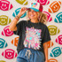 Neon Star Mascot DTF Transfers | School Spirit Mascot Collection, vibrant colorful neon star-shaped team spirit decals on a wall behind a cheerful woman wearing a matching graphic t-shirt and sporty cap.