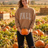 12 inch FALL corduroy plaid fabric applique in neutral brown, cream, black and tan colors displayed on a model in a pumpkin patch.